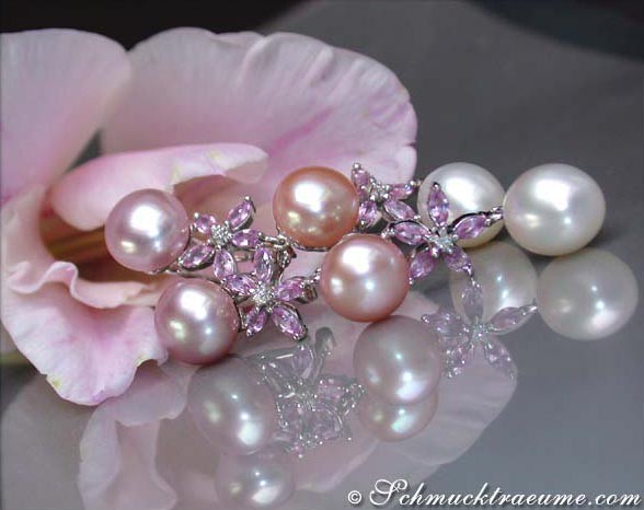 Pastellfarbene Süßwasserperlen mit Saphiren auf Blumenblättern, Detailaufnahme.