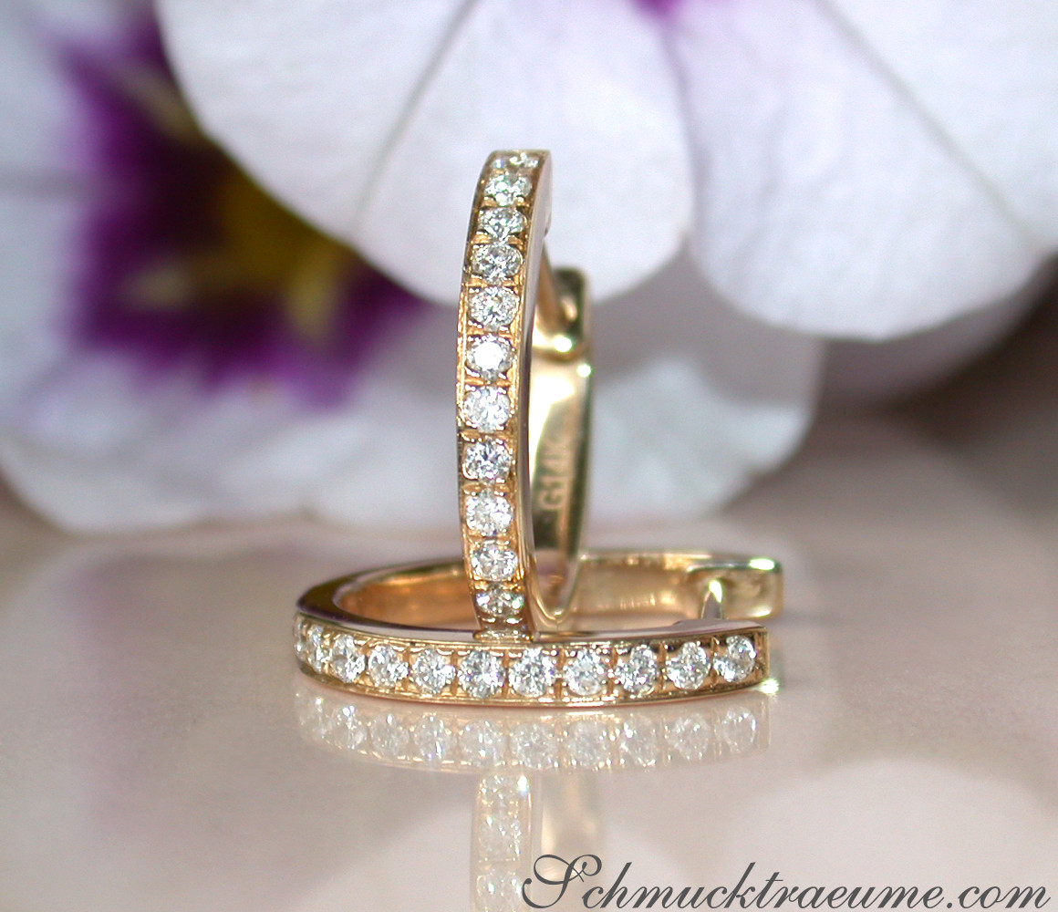 Gelbgold 585 Creolen mit Mini Brillanten, Detailaufnahme, weißer Hintergrund, Orchidee im Hintergrund.