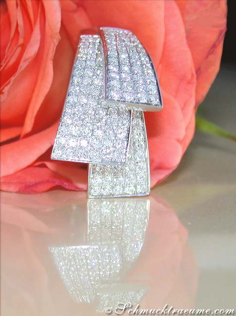 Fächerförmiger Brillantenring im Weißgold, detailreich mit funkelnden Diamanten, vor Rosenblüte.