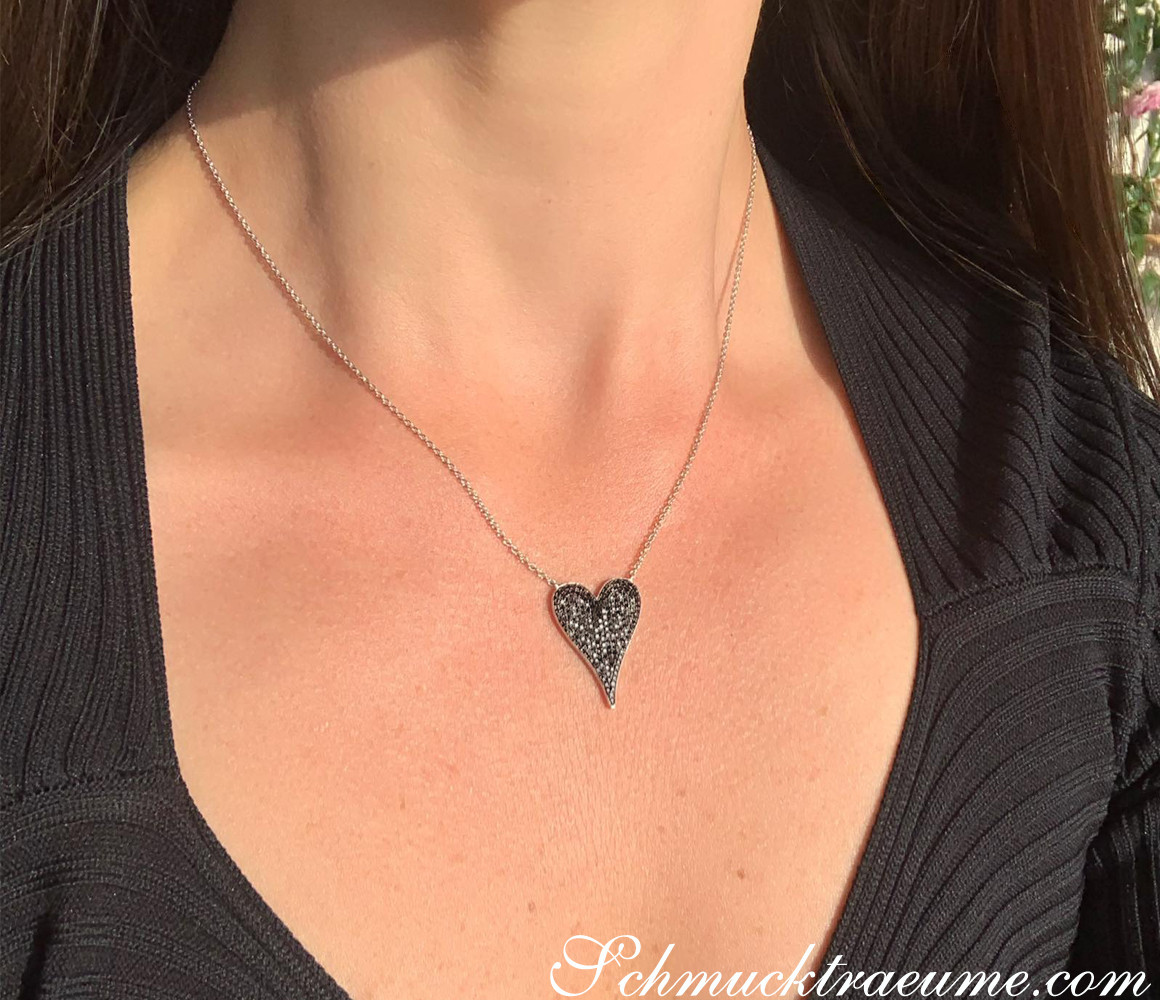 Detailansicht von schwarzem Diamantenherzanhänger, getragen auf Halskette