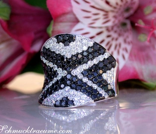 Schwarz-weiß Diamant-Zig-Zag-Ring auf glänzender Oberfläche