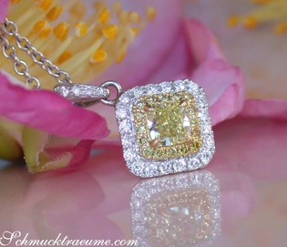Silberner Anhänger mit gelbem Diamant und Diamantkrone, rosa Blume im Hintergrund