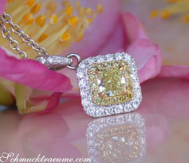 Silberner Anhänger mit gelbem Diamant und Diamantkrone, rosa Blume im Hintergrund Silberner Anhänger mit gelbem Diamant und Diamantkrone, rosa Blume im Hintergrund