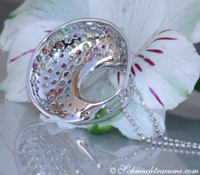 Weißgold Anhänger mit Regenbogen Saphir und Brillanten, Detailaufnahme, zarte Kette, Blume im Hintergrund