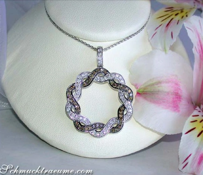 Weißgold-Anhänger mit braunen & weißen Diamanten, Detailaufnahme auf weißem Schaum, Blüten im Hintergrund. Weißgold-Anhänger mit braunen & weißen Diamanten, Detailaufnahme auf weißem Schaum, Blüten im Hintergrund.