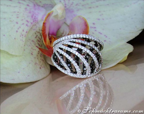 Schwarz-weißer Diamantring mit geschwungenen Linien, Orchidee im Hintergrund
