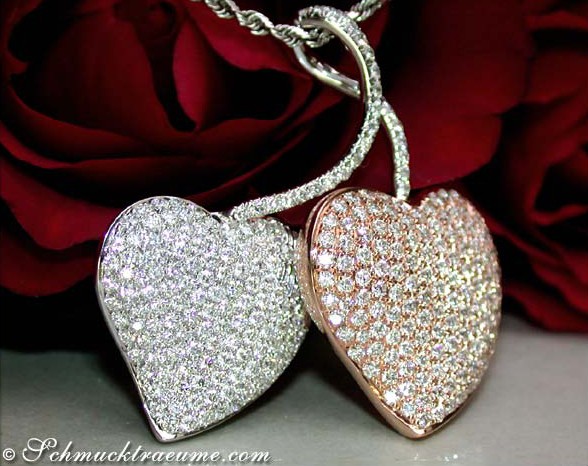 Detaillierte Herzanhänger aus Weiß- und Roségold, Brillantenbesatz, vor roter Rose.