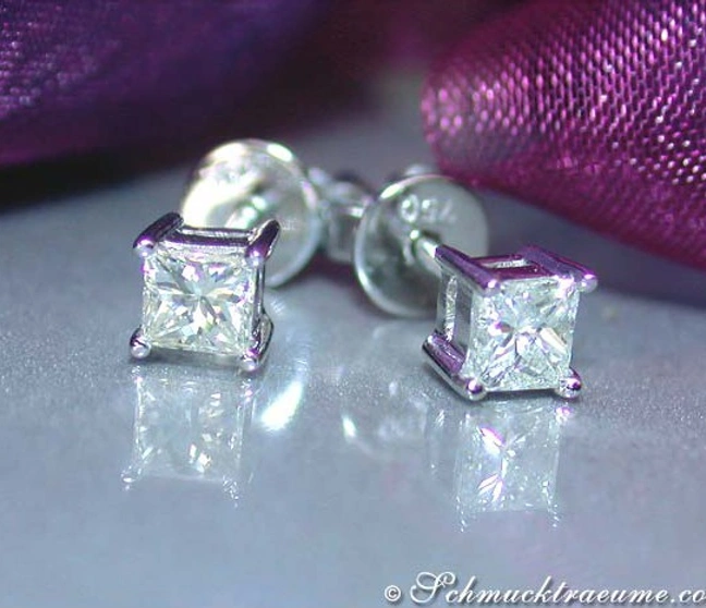 Prinzessdiamant-Ohrstecker in Weißgold, detailgetreu auf poliertem Hintergrund Prinzessdiamant-Ohrstecker in Weißgold, detailgetreu auf poliertem Hintergrund