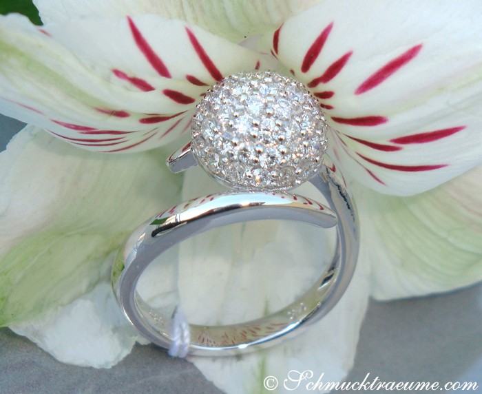 Detailansicht des Diamanten Pavé Kugel Rings auf weißem Blütenblatt