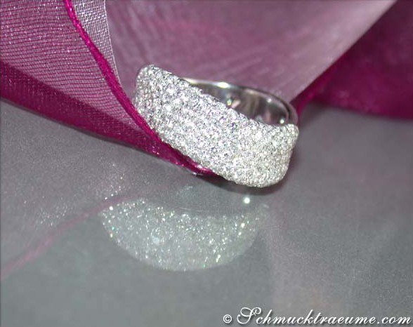 Weißgoldring mit geschwungenen Diamantenlinien auf rosa Tüll, Detailansicht.