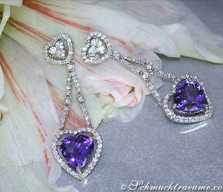 Herzformige Tansanit-Ohrringe mit Diamanten auf weißgoldener Basis, elegant auf Blüte platziert.