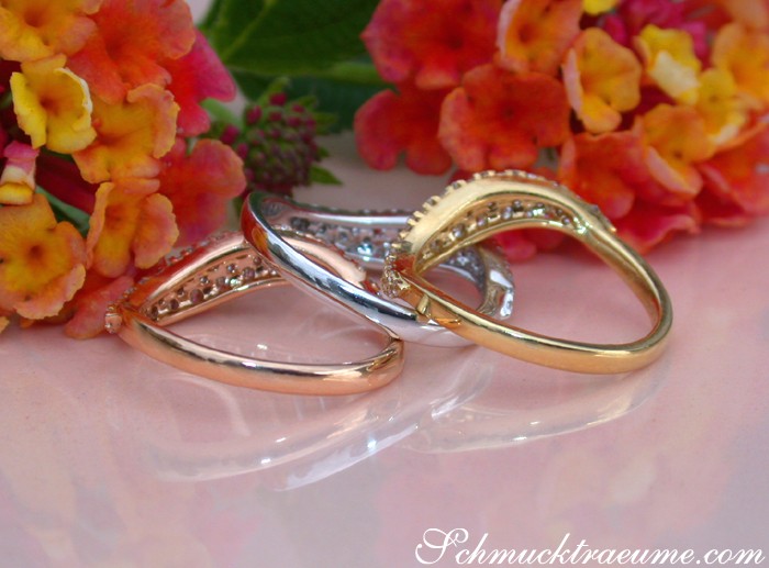 Blumenhintergrund, drei geschwungene Brillantenringe in Gold, Perspektive von oben