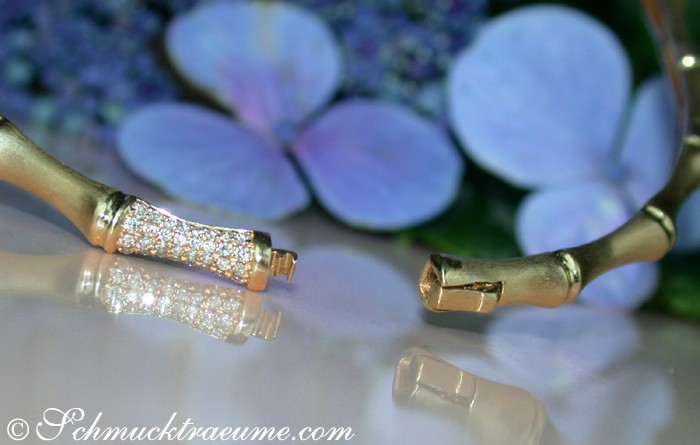 Edler Diamantenarmreif im Bambusdesign, satiniertes Gelbgold, Detailaufnahme, blauer Hintergrund, reflektierender Untergrund