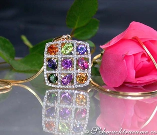 Multicolor-Edelstein-Anhänger mit Brillanten, prächtige Farben auf Goldkette, Rosenblüte im Hintergrund