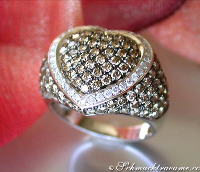 Weißgold-Ring mit cognac-braunen und weißen Diamanten, Detailaufnahme, auf Finger getragen. Weißgold-Ring mit cognac-braunen und weißen Diamanten, Detailaufnahme, auf Finger getragen.