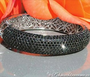 Schwarzer Diamanten-Armreif mit 992 schwarzen Diamanten, Detailaufnahme auf Blumenhintergrund