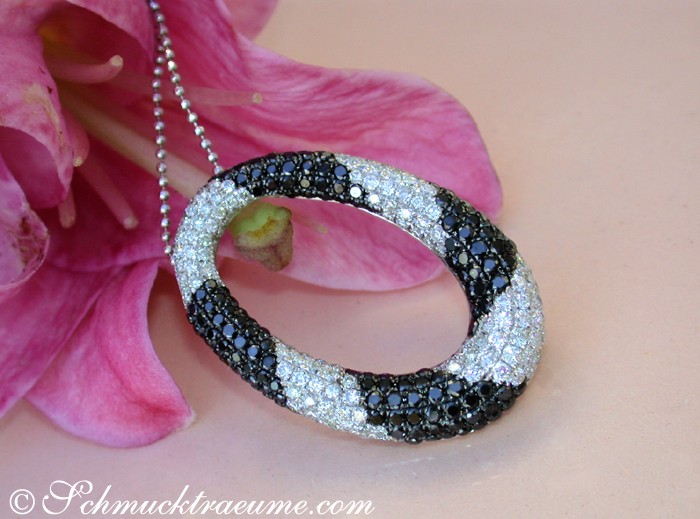 Schwarz-weißer Diamant-Anhänger mit Kreisform, elegant auf Blüte liegend