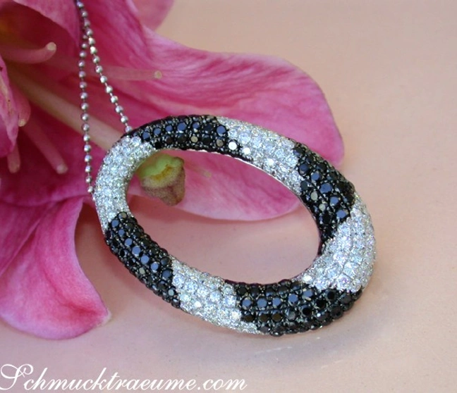 Schwarz-weißer Diamant-Anhänger mit Kreisform, elegant auf Blüte liegend Schwarz-weißer Diamant-Anhänger mit Kreisform, elegant auf Blüte liegend