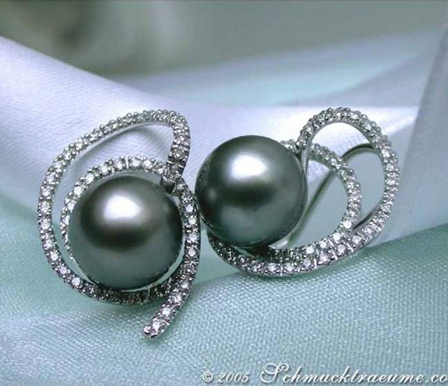 Tahitiperlen-Brillant-Ohrstecker mit weißgoldener Verarbeitung, Detailaufnahme auf Satin. Tahitiperlen-Brillant-Ohrstecker mit weißgoldener Verarbeitung, Detailaufnahme auf Satin.