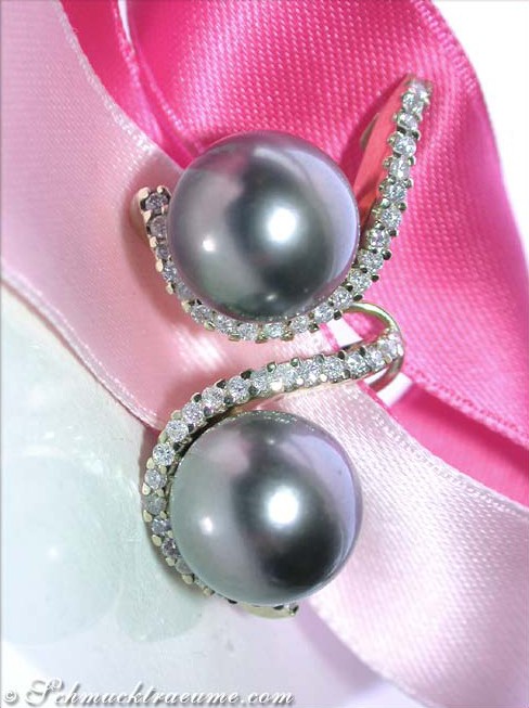 Gelbgold-Ohrstecker mit Tahitiperlen und Brillanten, Detailansicht auf rosa Stoff, elegant und luxuriös.