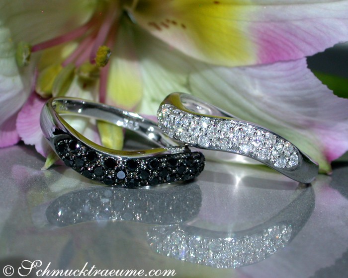 Geschwungener Diamantring mit Weißgold und schwarzen Diamanten, zarte Linien, Blütenhintergrund