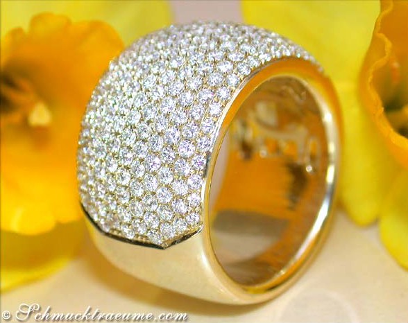 Gelbgold 750 Ring mit Brillanten-Pavé, detailreich, elegant, auf Blütenhintergrund.
