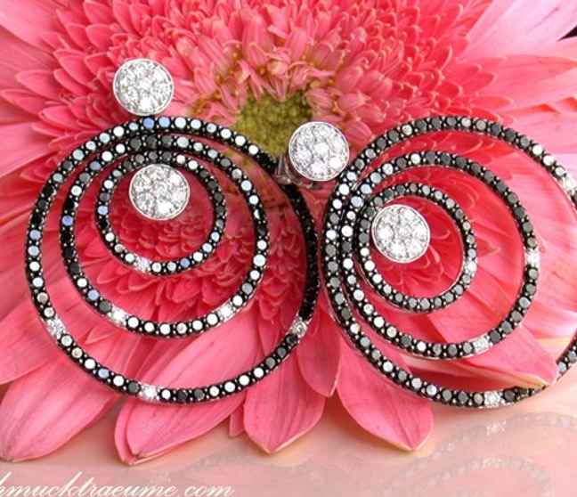 Schwarz-weiße Diamant-Ohrhänger auf rosa Blume, Detailaufnahme, elegant. Schwarz-weiße Diamant-Ohrhänger auf rosa Blume, Detailaufnahme, elegant.