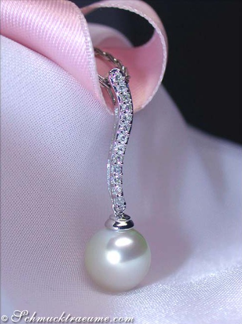 Perlenanhänger mit Brillanten auf weißem Stoff, Detailaufnahme