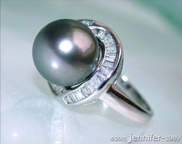 Weißgoldring mit Tahitiperle und Trapez-Diamanten, Detailaufnahme, seitlich getragen.