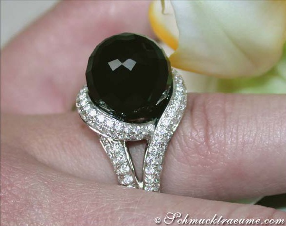 Weißgold Onyx Brillanten Ring mit Detailansicht und Blume im Hintergrund