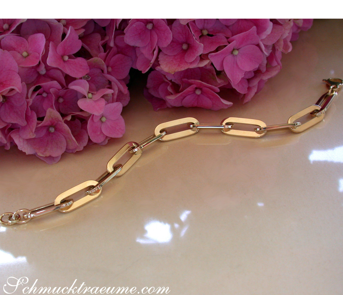 Gold-Paperclip-Armband in Gelbgold 585 mit klaren Linien und Blüten im Hintergrund