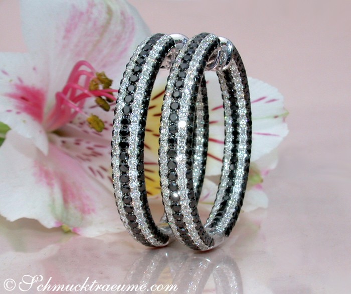 Schwarze und weiße Diamant-Creolen auf Blüte, Detailaufnahme