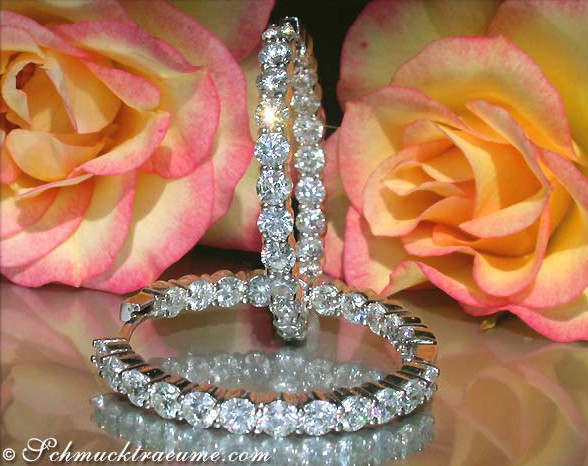 Weißgold-Creolen mit 9,06 ct. Brillanten, rosafarbene Rosen im Hintergrund