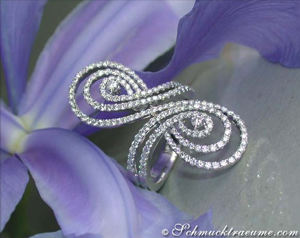 Blauer Blütenhintergrund, Detailaufnahme von silbernen Schlangenring mit Diamanten.