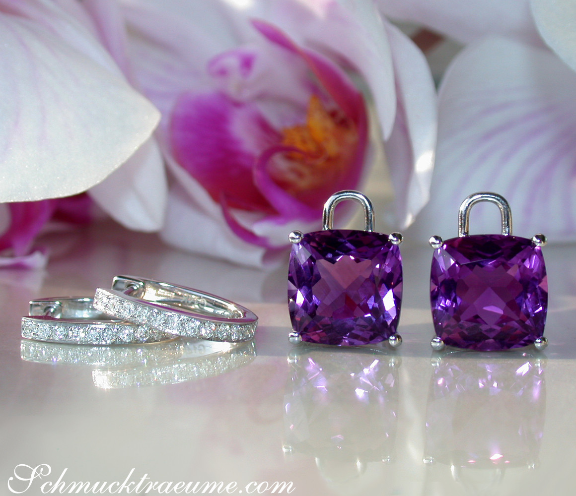 Kissen-Ohrringe aus Weißgold mit Amethyst und Diamanten, vor Orchidee