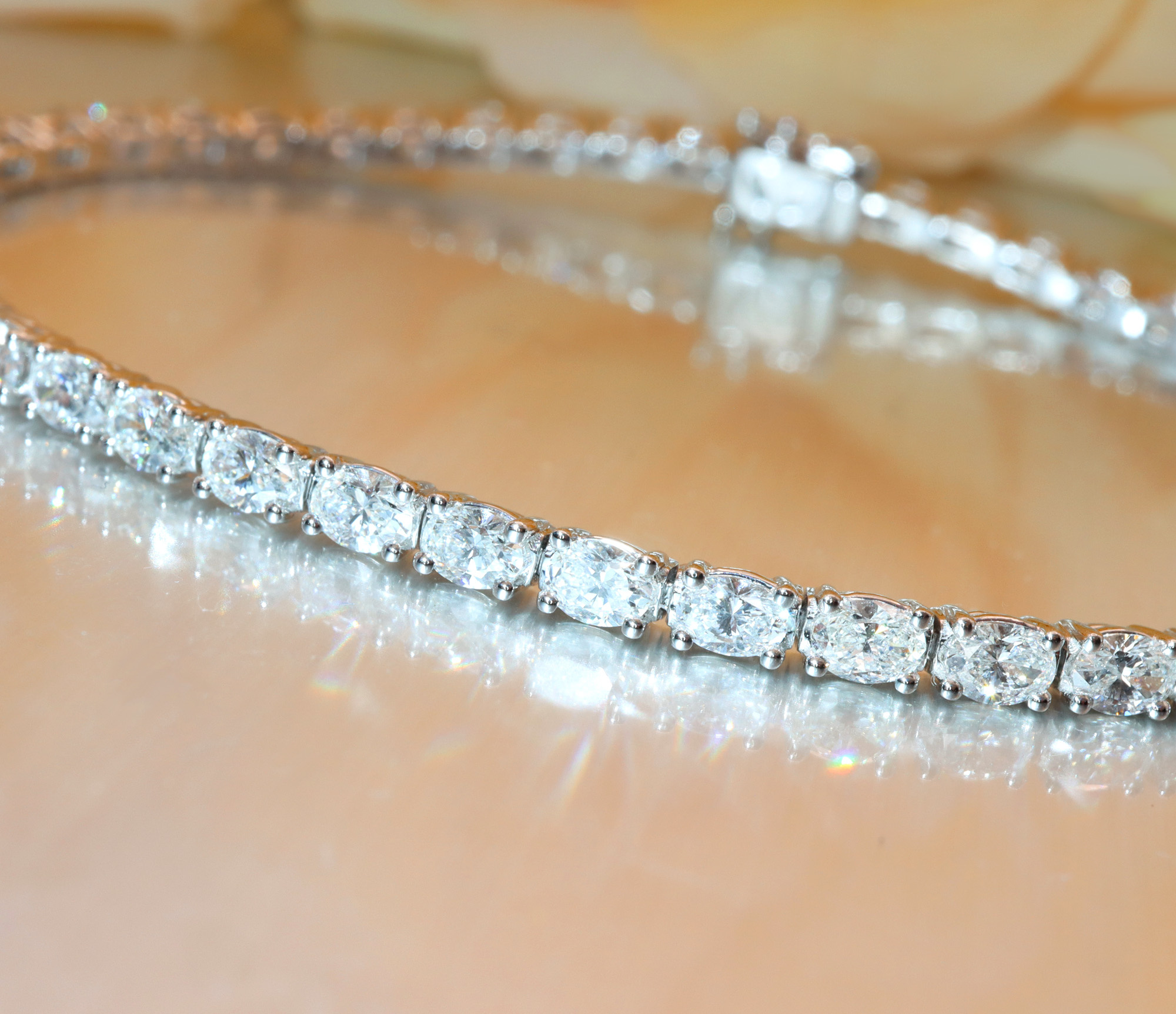 Diamant-Tennisarmband mit Ovalschliff in Weißgold, detailreich, glänzend, elegant.