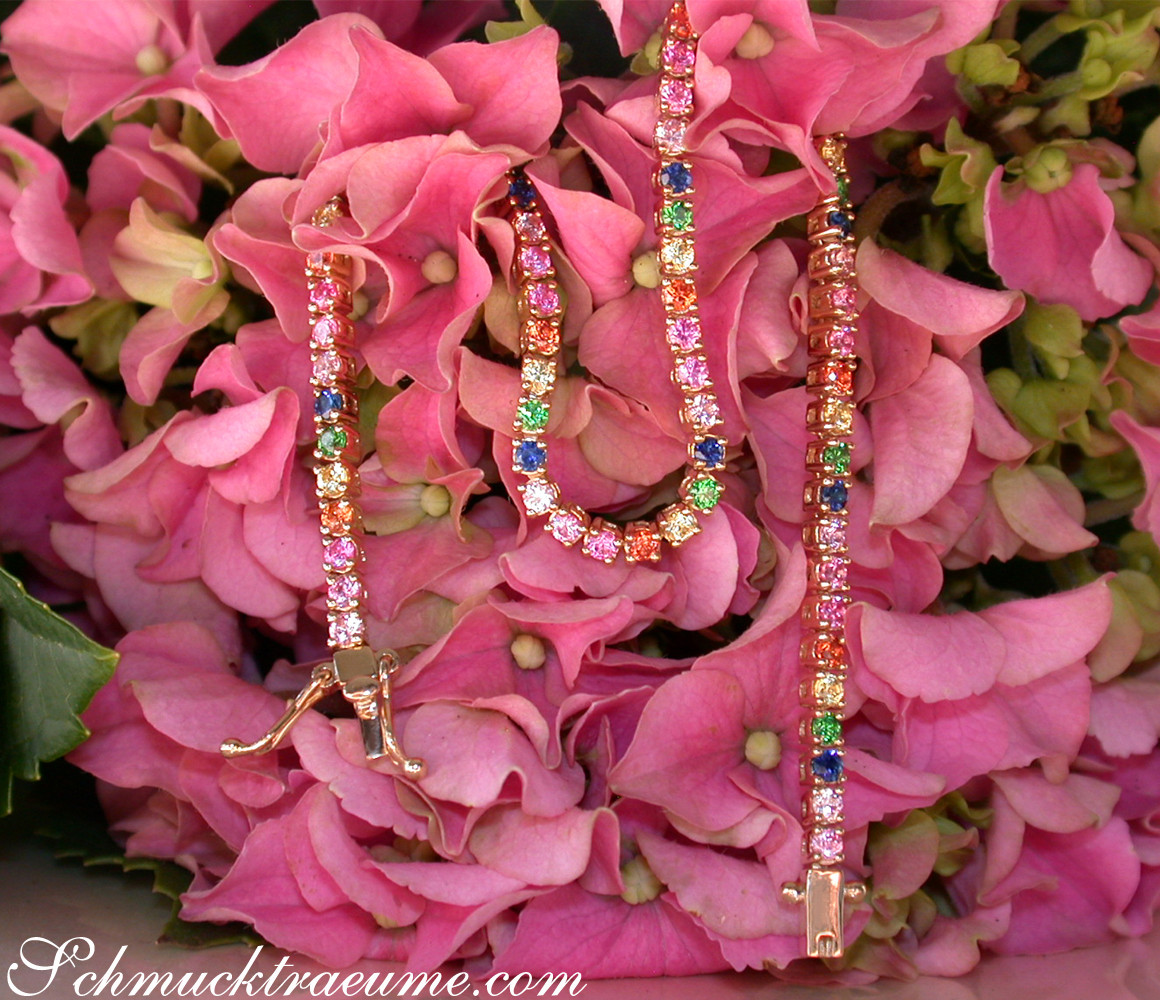 Gelbgold-Armband mit farbenfrohen Saphiren auf Blütenhintergrund