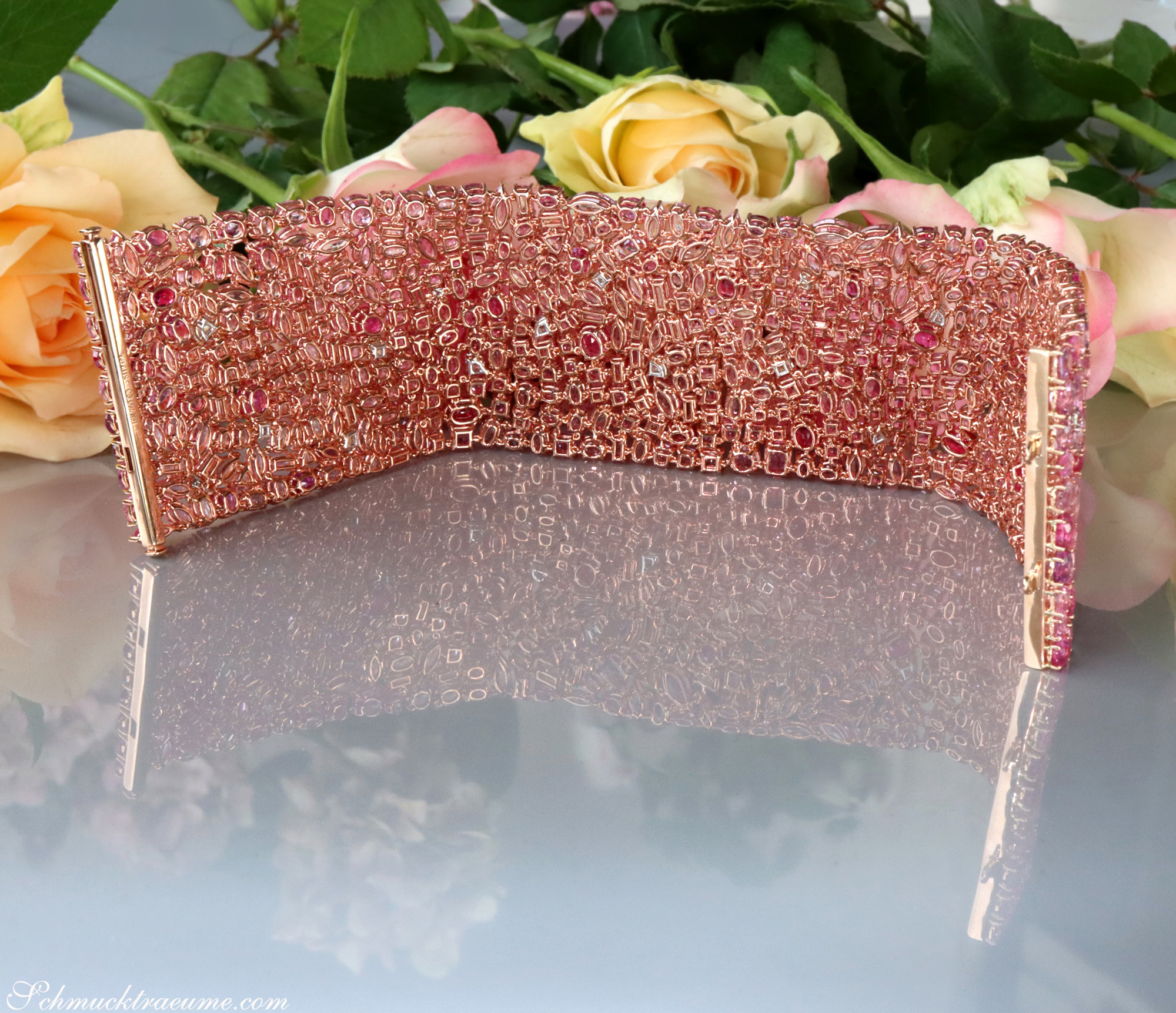 Pinkes Saphir-Armband mit 485 rosa Steinen, 115,07 ct., auf glänzender Oberfläche, umgeben von Rosenblüten.