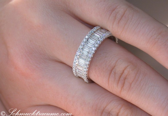 Diamantring mit Baguette- und Brillantschliff auf Handfinger, Detailansicht.