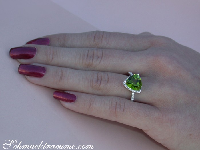 Weißgold-Peridot-Ring mit Brillanten, Detailaufnahme auf Hand, moosgrüner Stein funkelt.