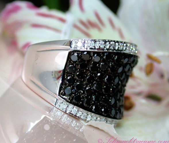 Schwarz-diamantener Ring mit Weißgold 585, Detailaufnahme mit Blumen im Hintergrund