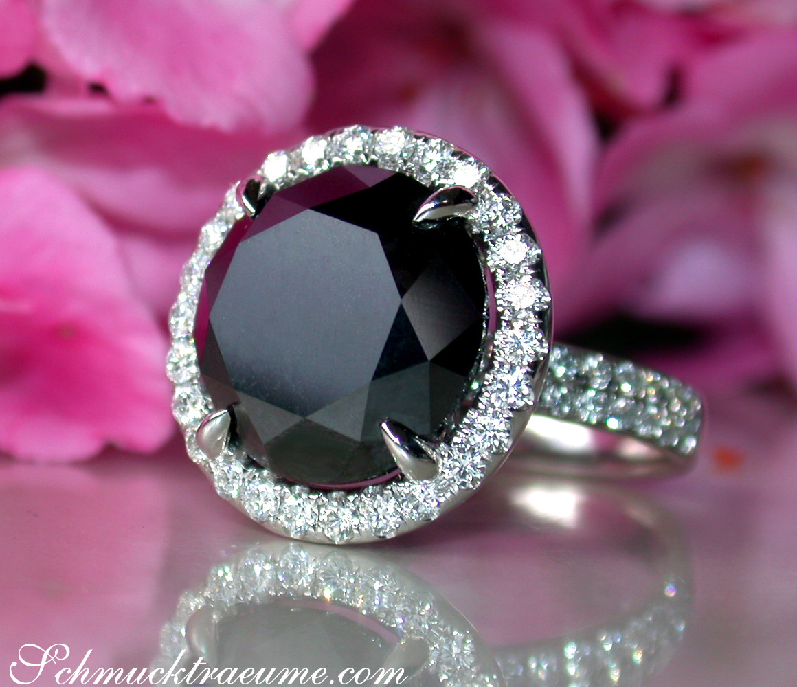 Schwarzdiamant-Solitär-Ring mit Diamant-Setzung, weißgold, Detailaufnahme, rosa Hintergrund.