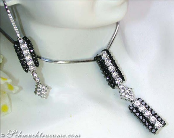 Schwarz-weißer Diamant-Anhänger mit langen Hängerdetails, getragen auf Puppenhals.