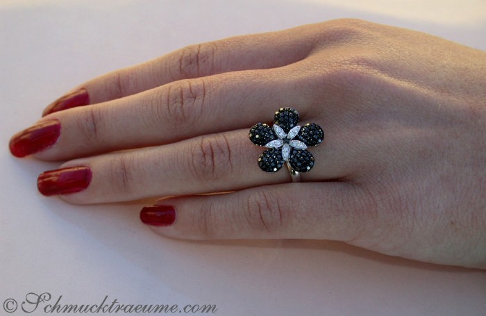 Blumenring mit schwarzen und weißen Diamanten, Detailaufnahme, Hand mit roten Nägeln, Weißgoldbasis
