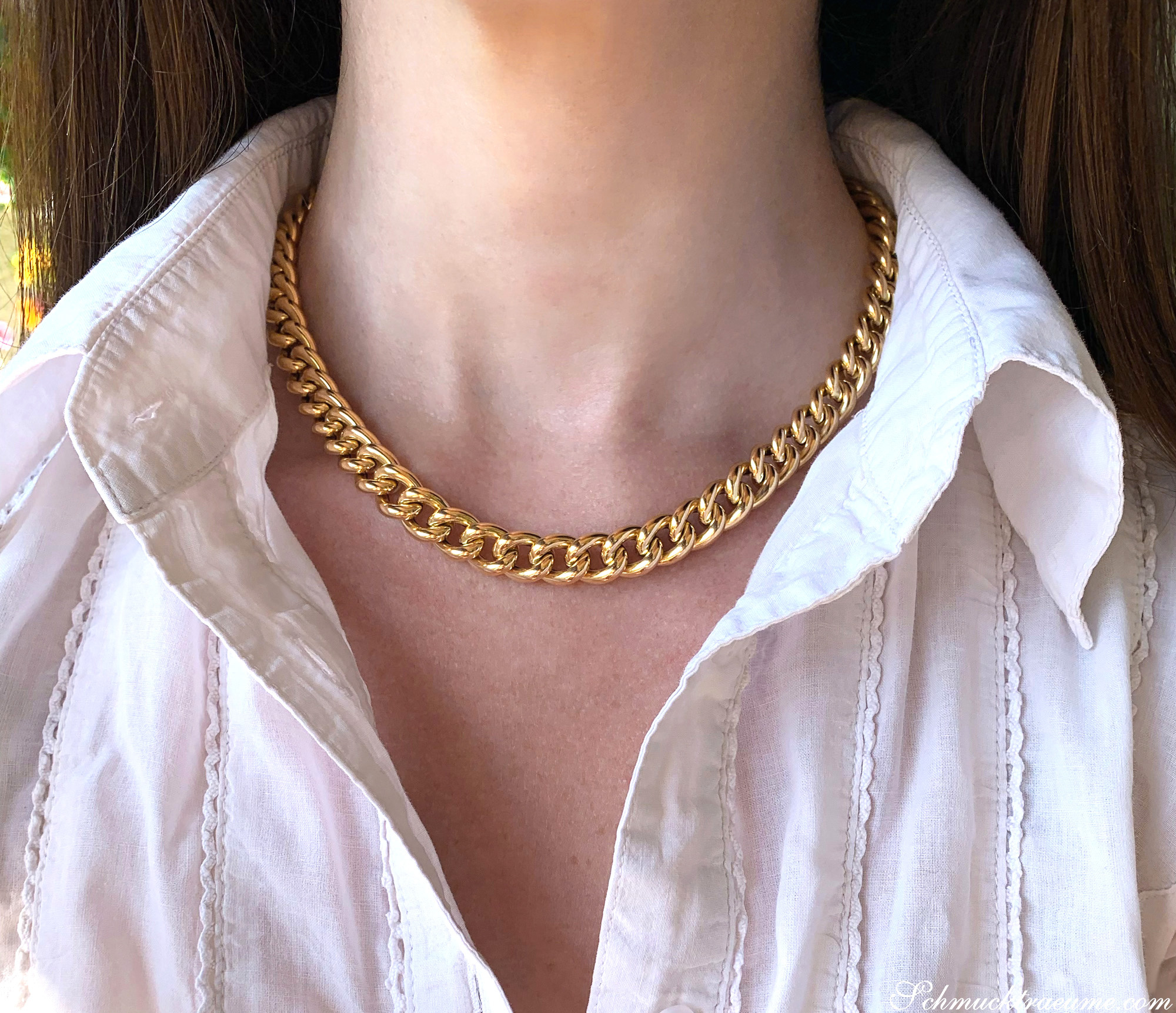 Goldene Panzerkette in Gelbgold 585, um den Hals getragen, mit weißem Hemd.