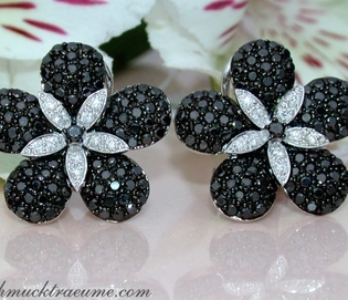 Schwarze Diamant-Blumenohrringe auf weißem Hintergrund mit Blütenmotiv.