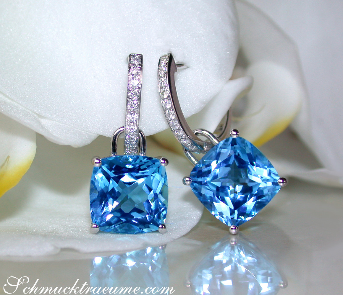 Blautopas-Kissen-Ohrringe mit Diamanten auf weißem Hintergrund