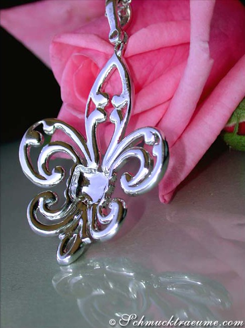 Silberner Fleur-de-Lis Anhänger mit Rosenblüte im Hintergrund