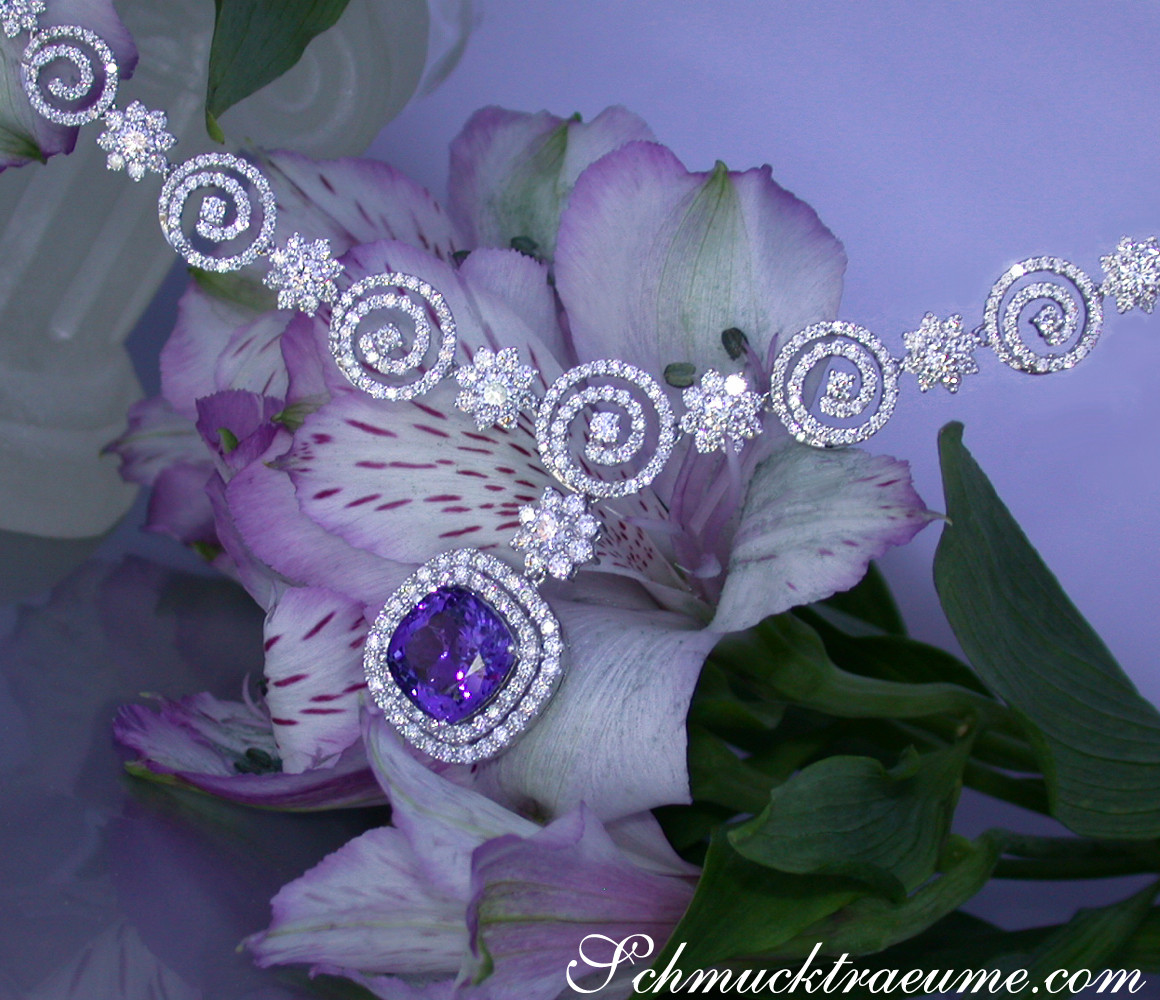 Floraler Hintergrund mit Tansanit-Collier in Weißgold, Detailansicht der Schmuckstücke.