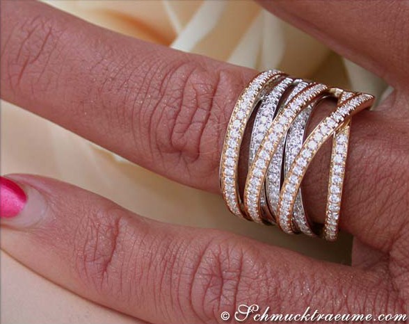 Mehrzeiliger Diamantring in Bicolor-Gelbgold, elegant gestapelt, auf Hand mit rotem Nagellack.